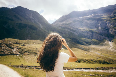 Rear view of woman standing on landscape against mountains