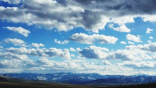 Snow covered mountains against cloudy sky