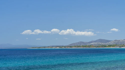 View of calm blue sea against mountain range