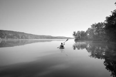 Man on lake against sky