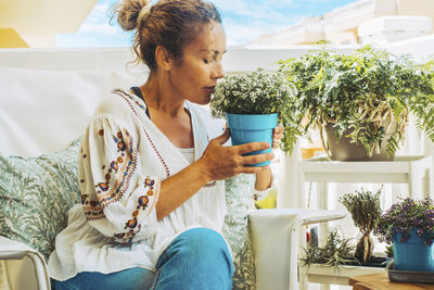 Young woman using mobile phone while sitting at home