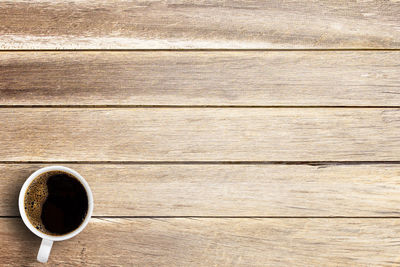 Directly above shot of coffee cup on wooden table