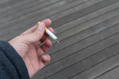 Cropped hand holding cigarette