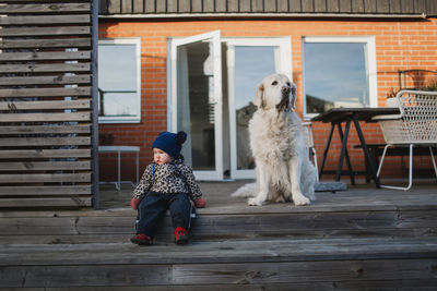 Baby girl and dog on patio