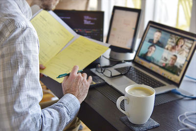 Midsection of man using laptop on table