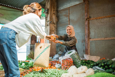 Portrait of woman holding vegetables for sale