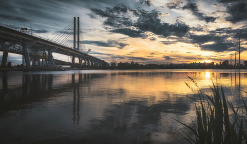 Bridge over river against sky during sunset