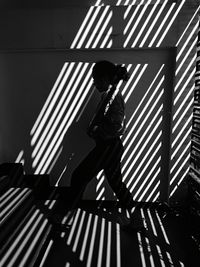 Silhouette woman walking on steps with shadow at home