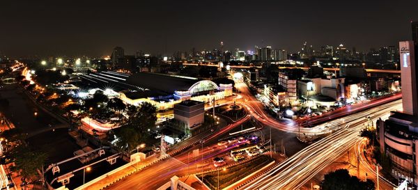 High angle view of illuminated street amidst buildings in city at night