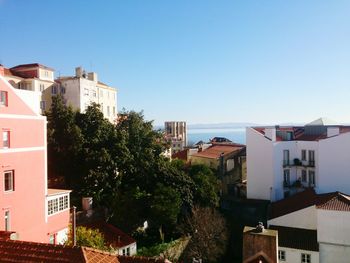 Houses in town against clear blue sky