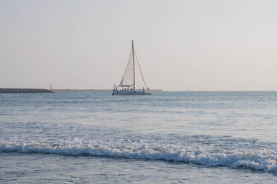 Sailboat sailing on sea against clear sky