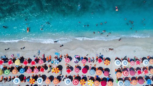 Aerial view of colorful umbrellas on shore at beach