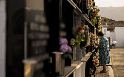 Old lady mourning her family in cemetery