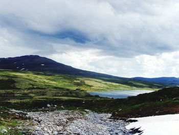 Scenic view of lake against cloudy sky