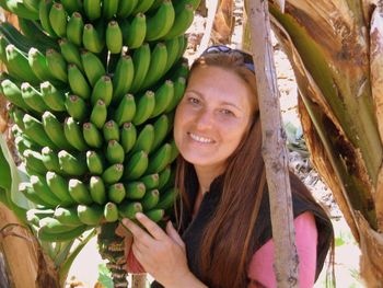 Portrait of smiling woman by bananas