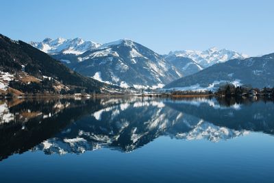 Scenic view of alpine lake and snowcapped mountains against sky