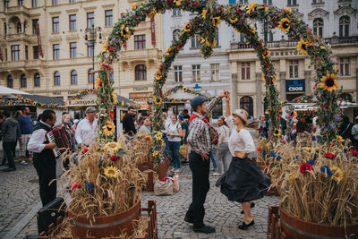 People on street against buildings in city