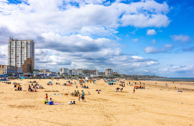 People at beach against sky