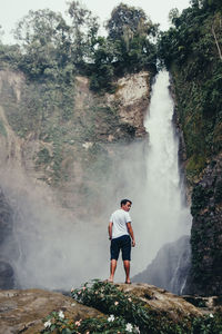 Man surfing on waterfall in forest