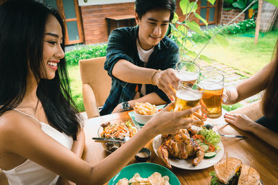 Midsection of woman holding drink on table at restaurant