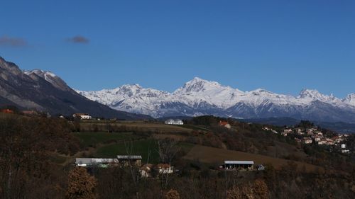 Scenic view of snowcapped mountains against clear blue sky