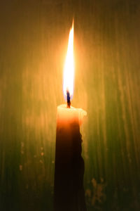 Close-up of lit candle in the dark