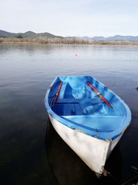 Boat moored in lake against sky