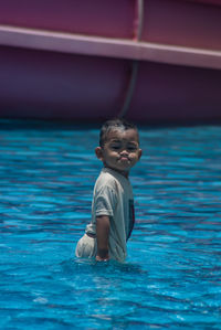 Portrait of boy with adorable expression at swimming pool 