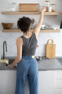 Rear view of woman standing at home