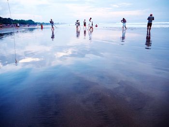 People at beach against sky