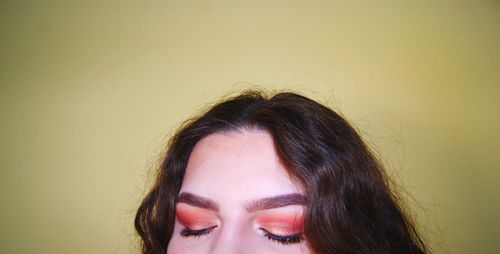 Close-up portrait of woman against wall