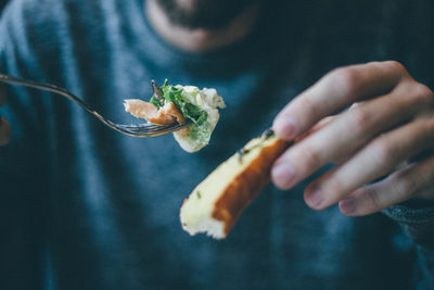 Midsection of man holding bread and salad