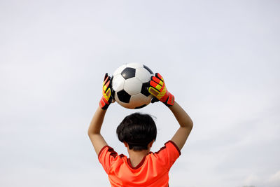 Midsection of man holding soccer ball