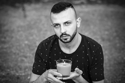 Portrait of young man drinking glasses outdoors