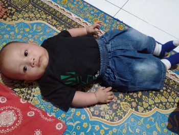 Portrait of cute boy lying on floor