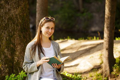 Cute girl in the park with a book in hand