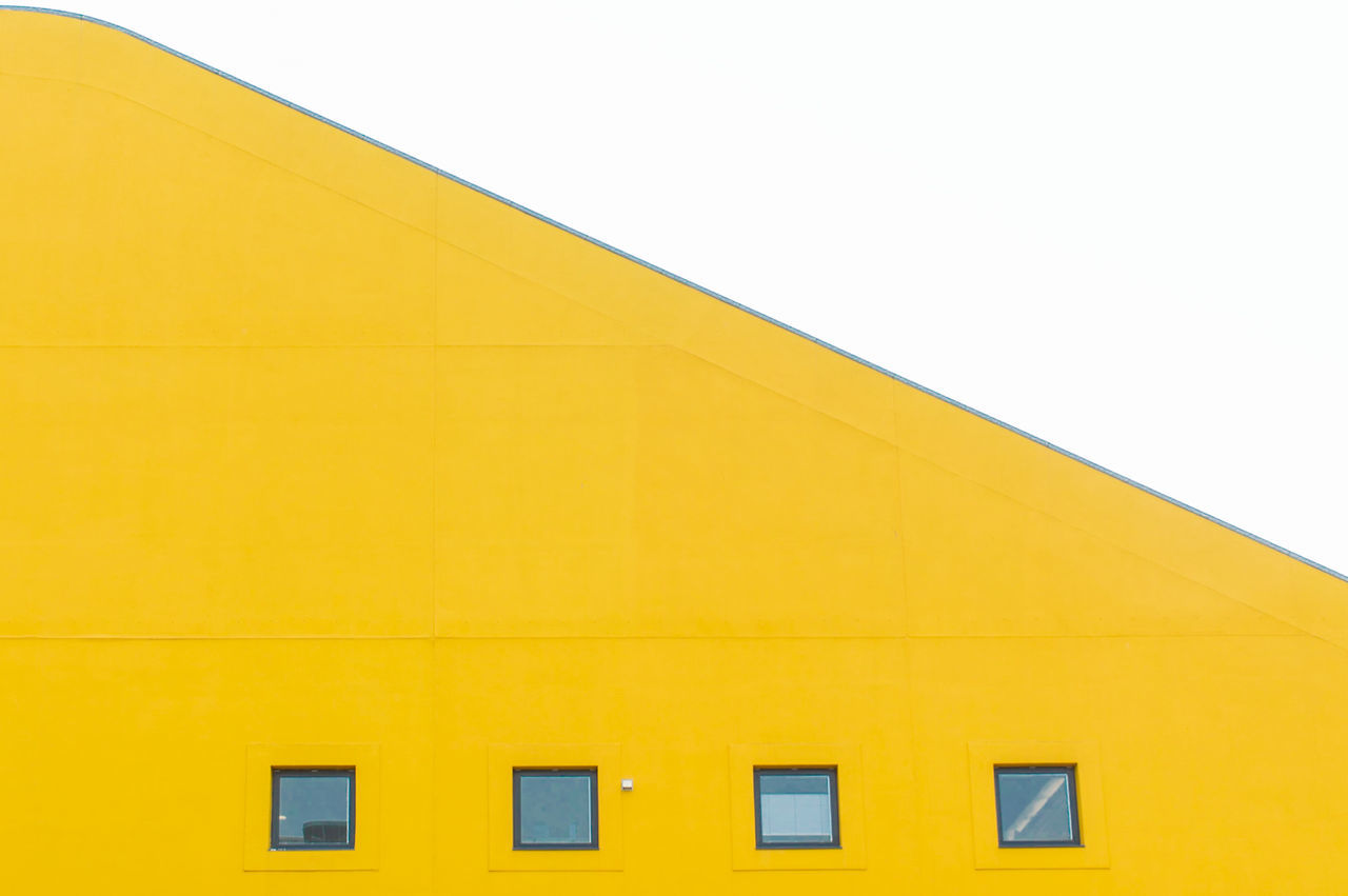 architecture, built structure, building exterior, yellow, window, building, sky, low angle view, clear sky, no people, copy space, nature, residential district, day, outdoors, wall - building feature, city, roof, shape, full frame