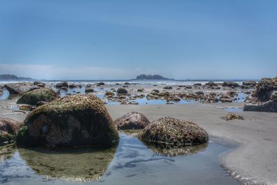 Panoramic view of rocks on beach against sky