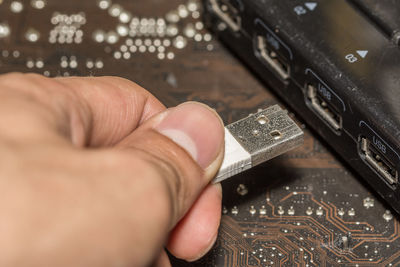 Cropped hand holding usb cable