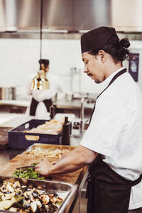 Midsection of man preparing food in restaurant