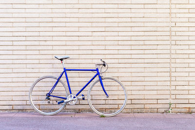 Vintage blue bike leaning on a city brick wall