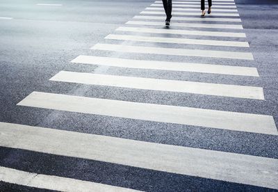 Low section of people walking on zebra crossing