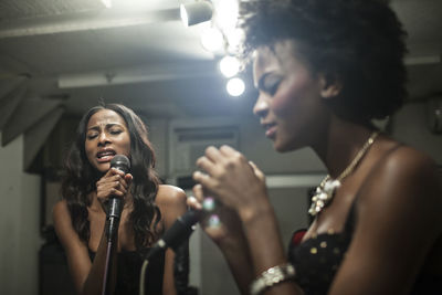 Young women singing in a recording studio