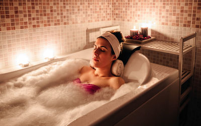 Young man lying down in bathroom