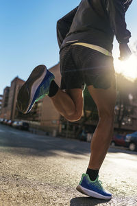 Low section of man running on street