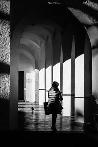 Rear view of woman walking in corridor