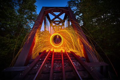 Low angle view of illuminated ferris wheel at night