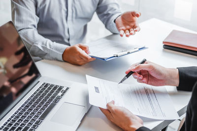 Midsection of businessman working at desk in office