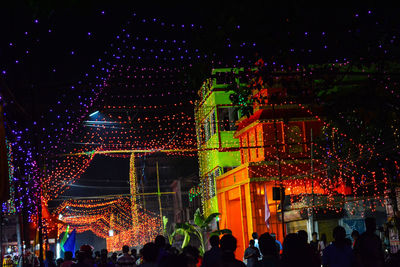 Crowd on illuminated christmas tree at night