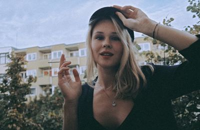 Portrait of young woman smoking cigarette in city